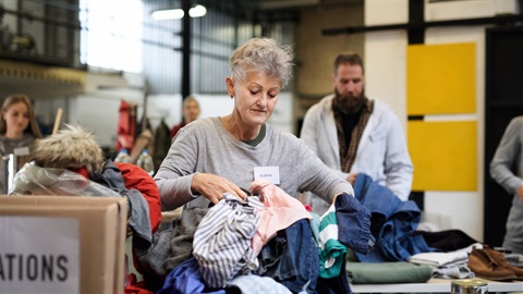 a lady sorting out op shop clothes
