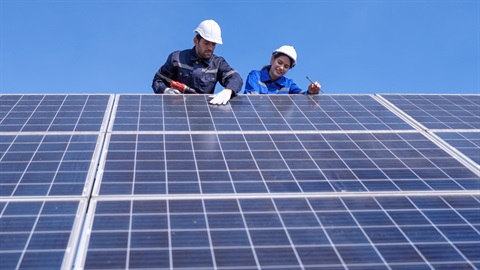 Two workers inspecting solar panels