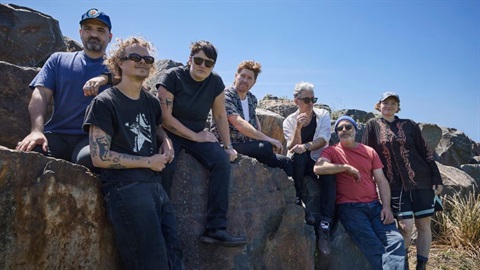 A group of men and women sitting on large boulders.