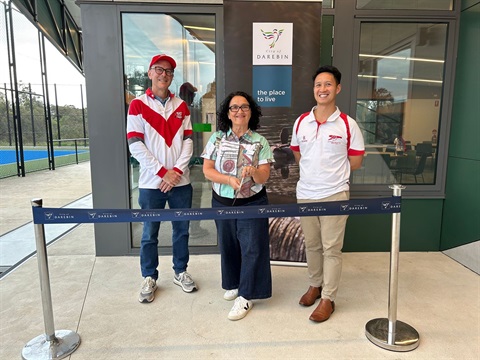 A woman cuts a Darebin council ribbon as part of an opening ceremony for the KP Hardiman Reserve