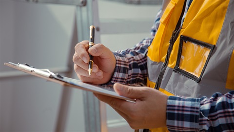 A person holding a clipboard and pen