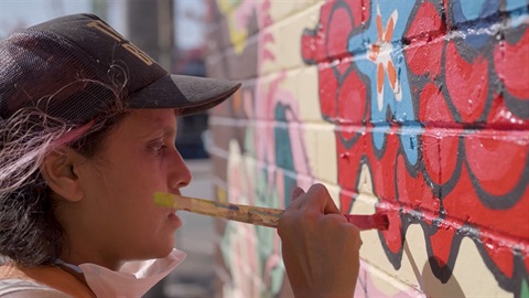 Artist TextaQueen paints a mural in Reservoir
