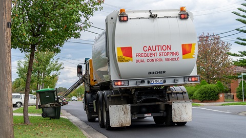 Garbage truck picking up a garbage bin