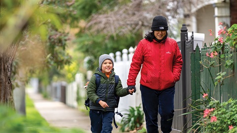 Parent and child walking along street