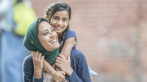 Refugee Week 2022 A daughter gets a ride on her mother's back