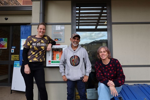 Reservoir Neighbourhood House's Kate, Thorne and Lia show off their new defibrillator.