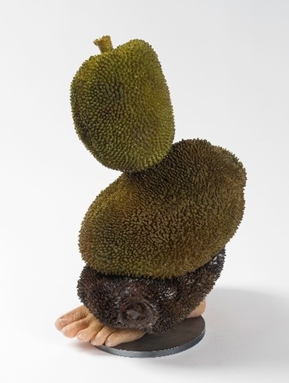 An abstract sculpture depicting a foot and greenery.