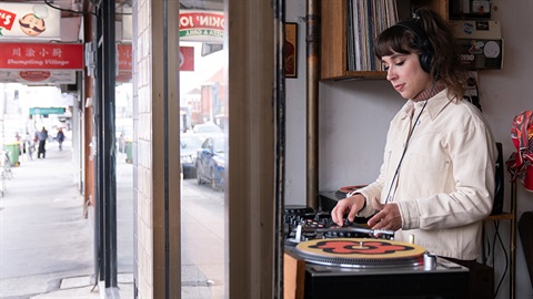 Young person spins some soulful vinyl in a High Street shop front