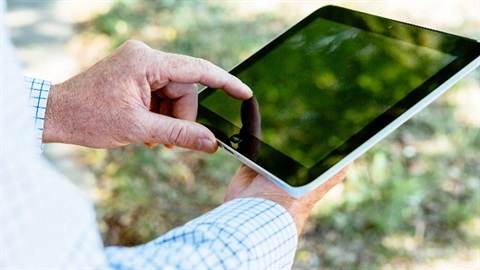 Person holding a tablet device whose screen is off