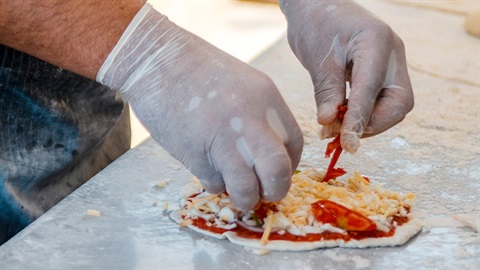 Chef preparing a pizza in a commercial kitcken