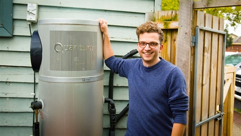 A person leaning against an efficient heat pump hot water service out the back of a cafe