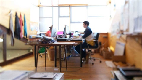 Person sitting at a desk working at a computer 