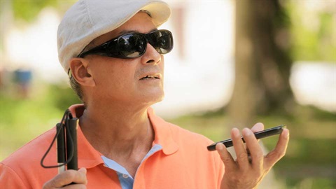 blind person listening to mobile phone
