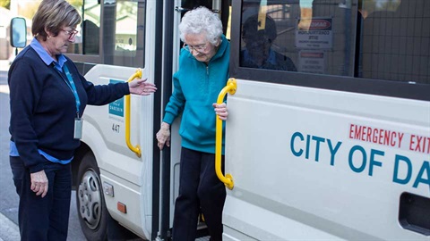 council carer assisting older person leave bus