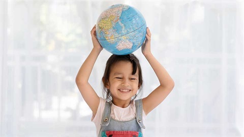 young child balancing globe of world on head
