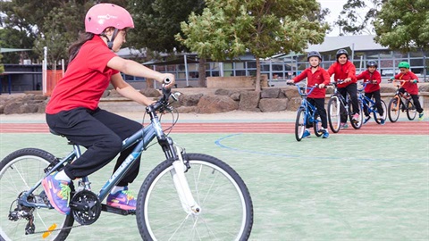 school child riding bike in school yard