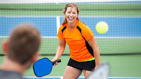 Two people playing pickleball on a court