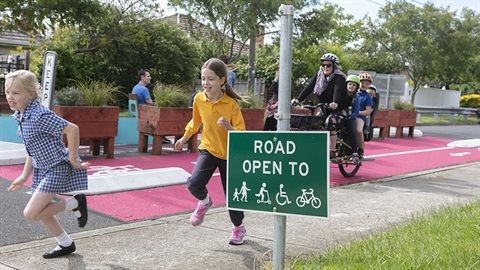 Children and bicycles travelling along a street