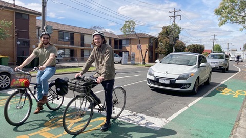 Cyclists and cars stopped at an intersection