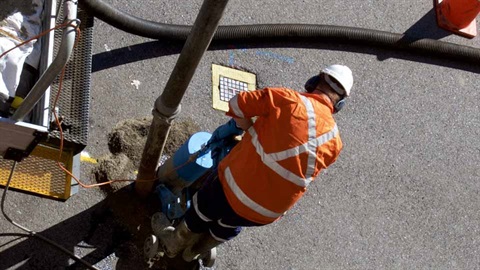 worker drilling in road