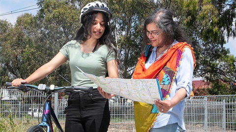Two people with a bike looking at a map