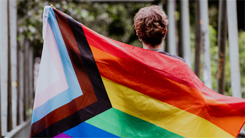 Person with a rainbow flag at pride event