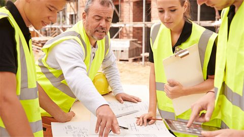 Builder talking to workers pointing to plans