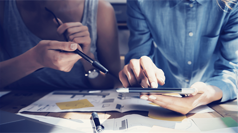 Two people reviewing building plans on a phone