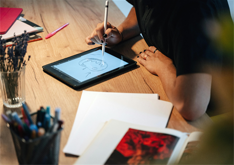 person drawing on ipad