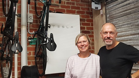 Jodie and Angus in front of their Tesla Powerwall