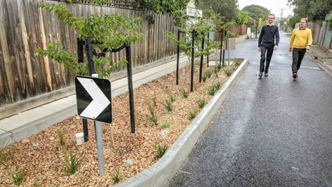 Two people walking next to nature strip