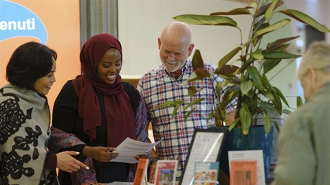 People in the Darebin Intercultural Centre looking at a document.